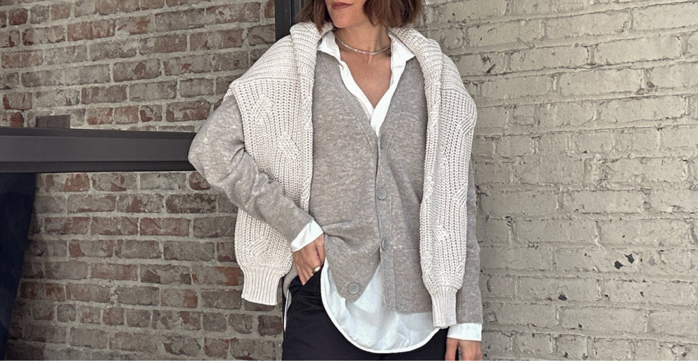 Women leaning against grey brick wall with Looker 