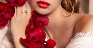 Woman holding red flowers up to her cheek with red lipstick